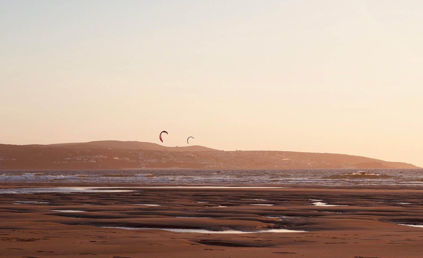 Solnedgang kitesurf session på Gwithian strand, Cornwall.