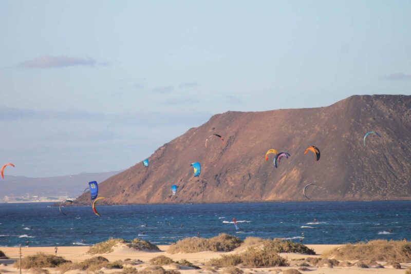 Kitesurfing na Fuerteventuře s horským pozadím.
