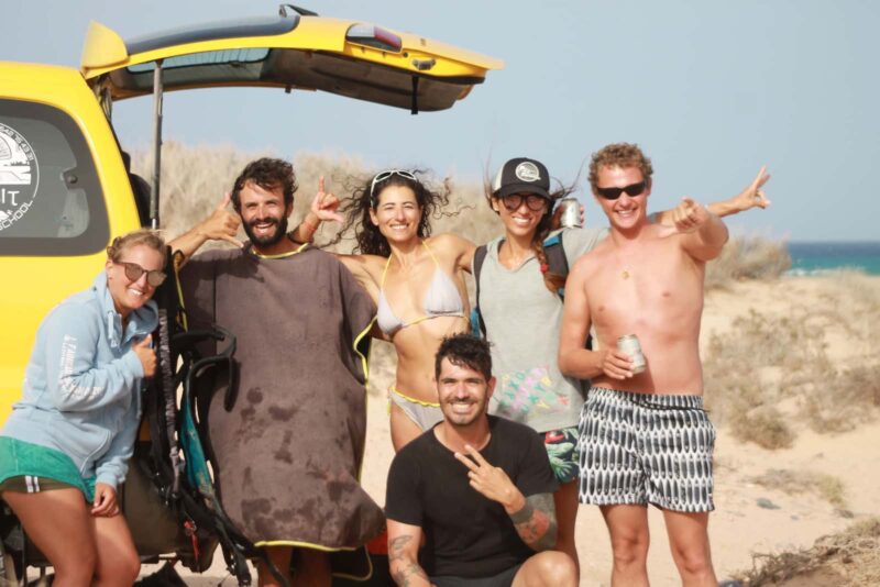 Happy kitesurf campers posing on the beach.