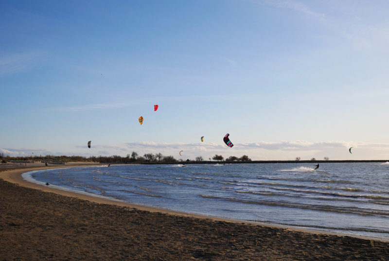 Kite spot nära Montpellier, Frankrike. Många drakar i luften.