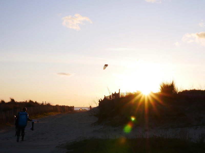 Solnedgang med kite-silhuett.