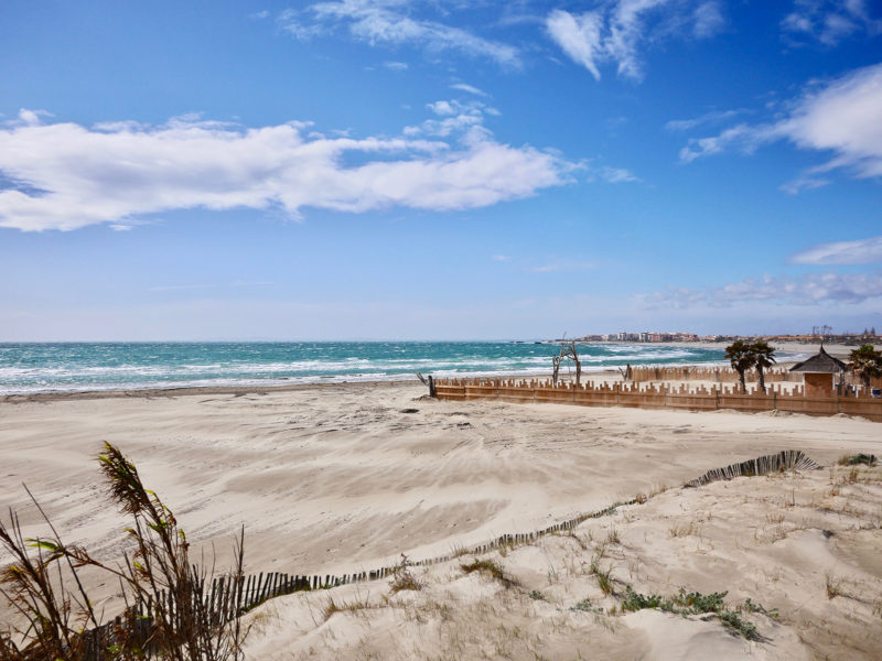 Winderig strand op een zonnige dag buiten Agde, Zuid-Frankrijk.