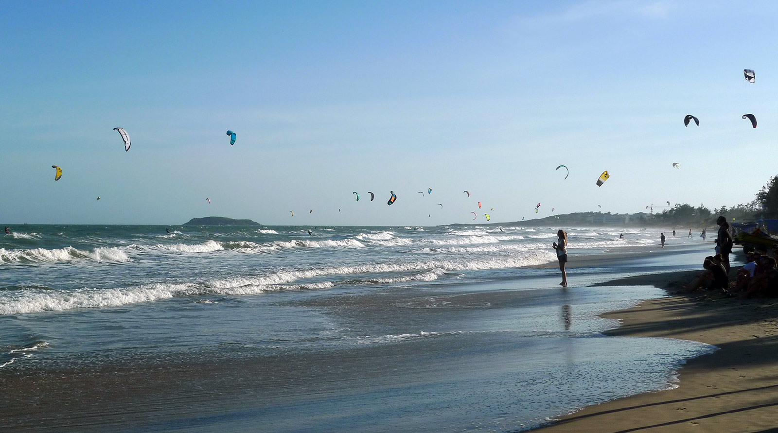 Malibu kitesurf spot, Mui Ne. Kites flying and waves on the water.