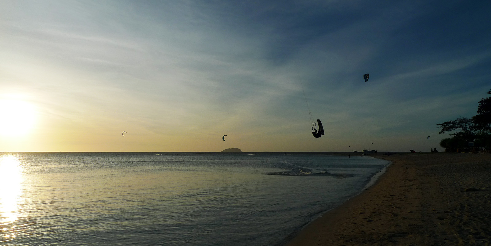 Kiteboarder dara triku ļoti plakanā ūdenī Capusan pludmalē, kitesurfing Cuyo.