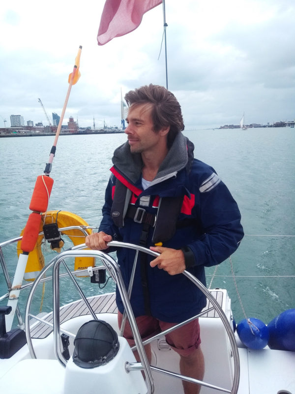 Martin at the helm of a sail yacht